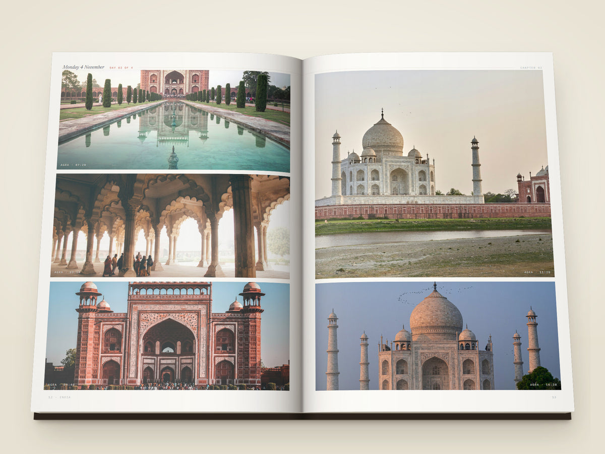 The same A4 portrait softcover Travel Book, open on the table. Two printed pages of photographs from Agra — the Taj Mahal over its long reflecting pool, a corridor of carved arches, the great gate, the Taj from the far riverbank and its dome against a pale sky, each with the time it was taken