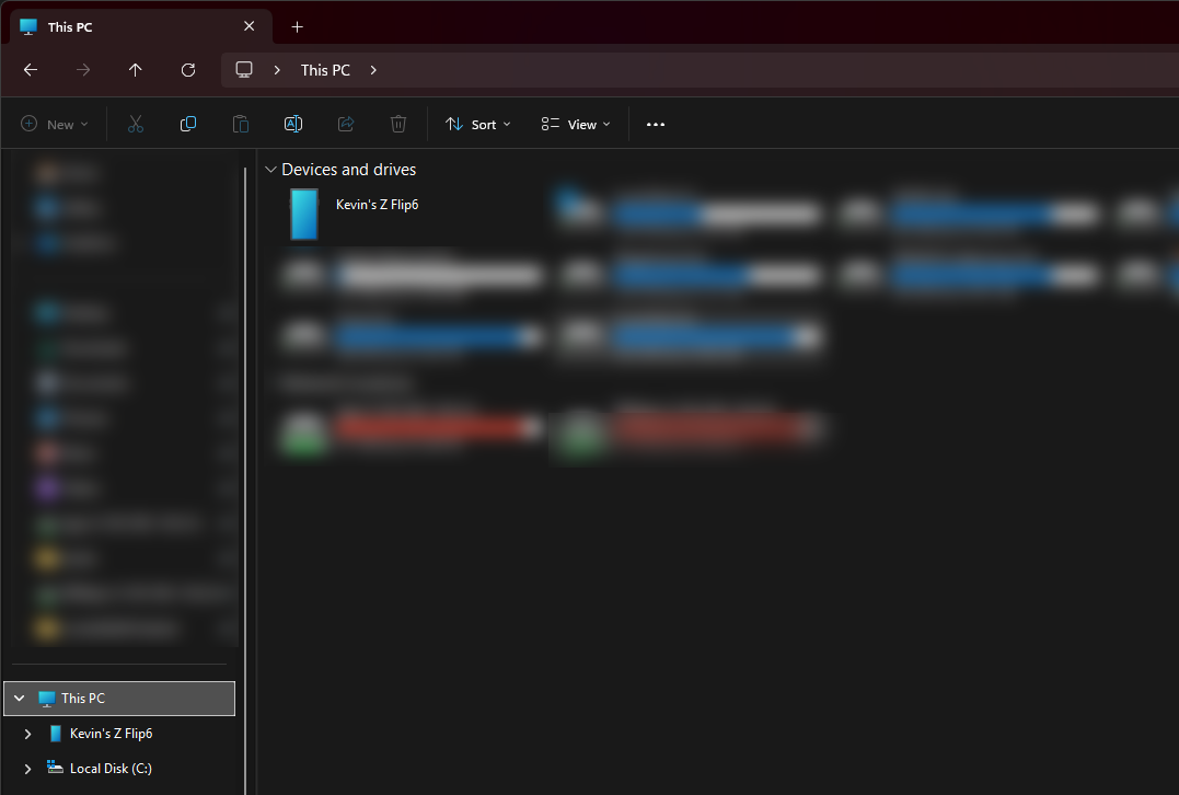 File Explorer open on This PC, the phone listed by name under Devices and drives