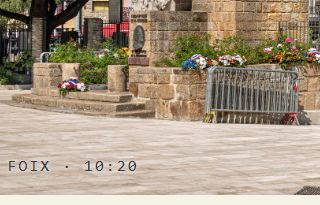 A printed page, close on the monument below the castle towers, stamped FOIX · 10:20
