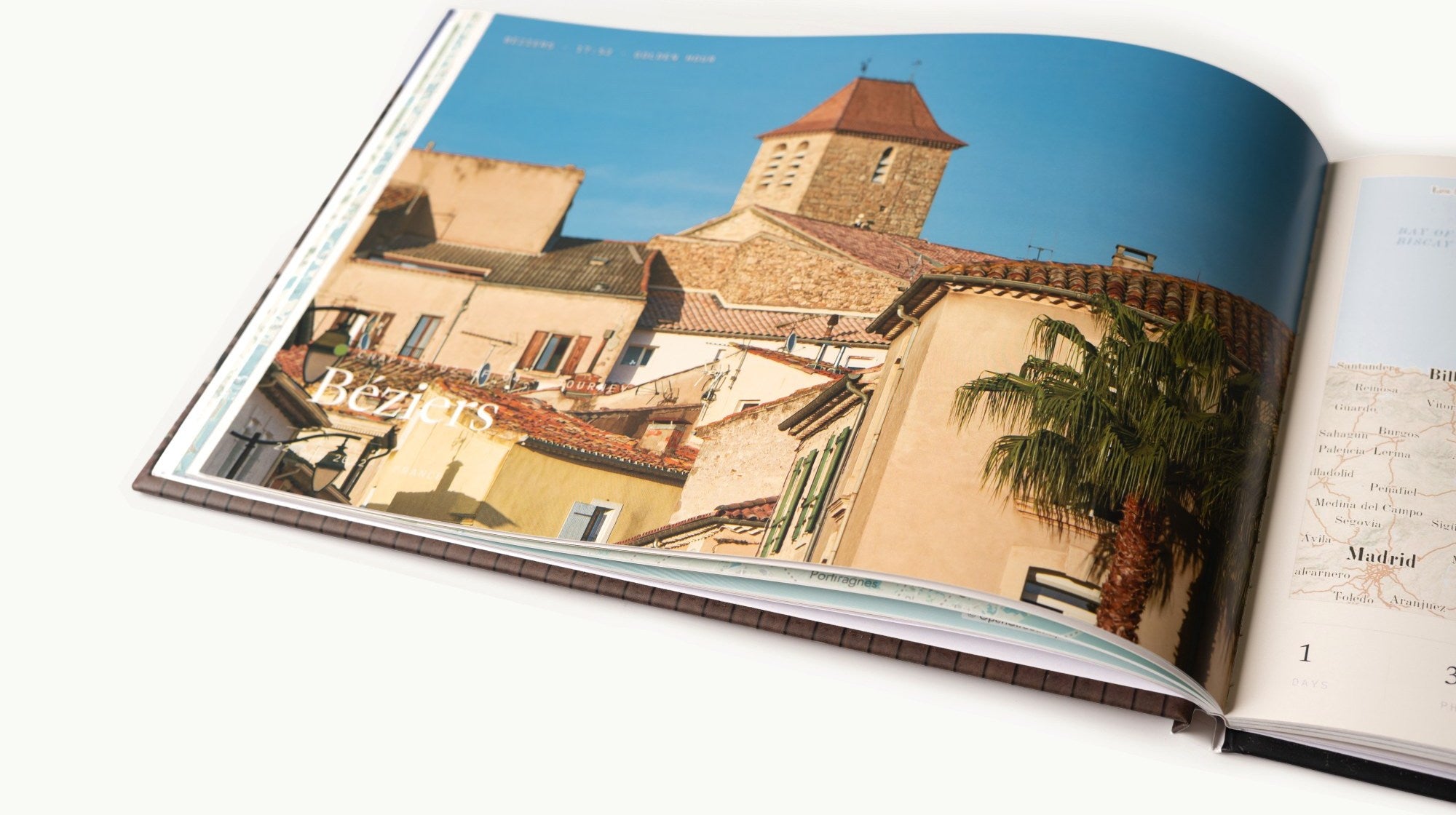 A finished Travel Book lying open: a full-bleed chapter opening for Béziers on the left page, the trip’s map of northern Spain on the right