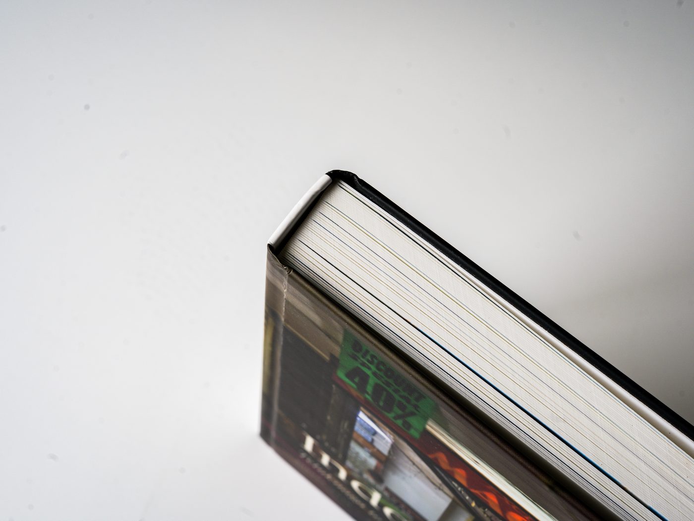 The closed book seen from the side, its page edges fanned in raking light