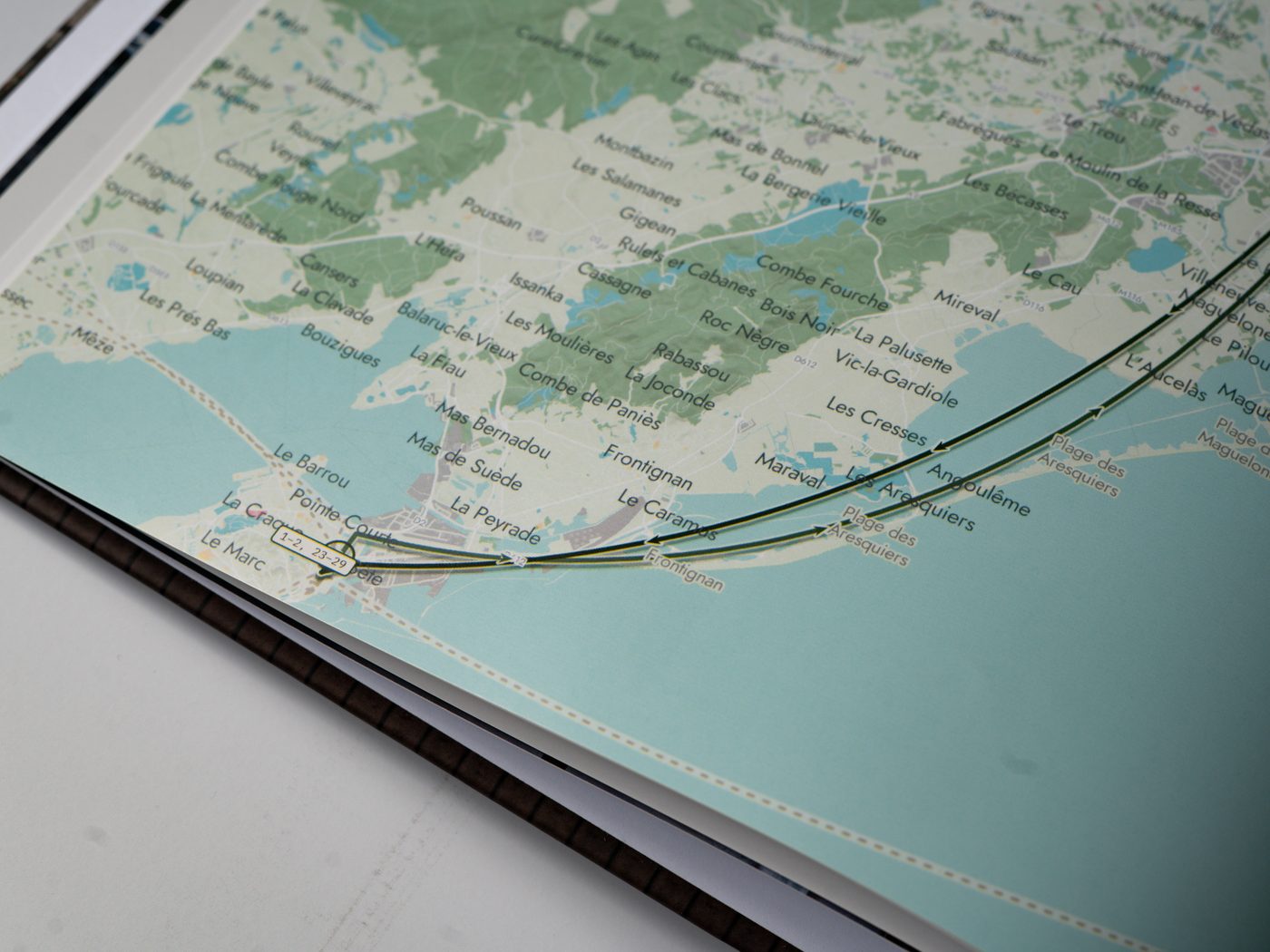 Close-up of a printed map page — town names, the route line and the fine road hairlines