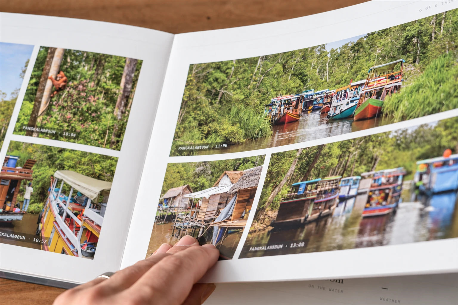 A hand holding the book open at a spread of river boats and an orangutan in Pangkalanbun, each photo stamped with its place and time