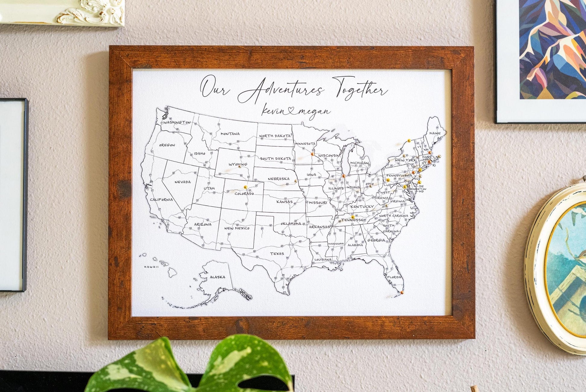 Framed 11x14" push pin USA map in black and white hanging on a wall, displaying labeled U.S. states and interstate highways with a minimalist design. Personalized travel map for tracking adventures.