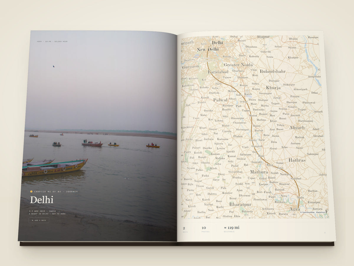 The same A4 portrait softcover Travel Book open on the table, a spread of photographs printed across both pages