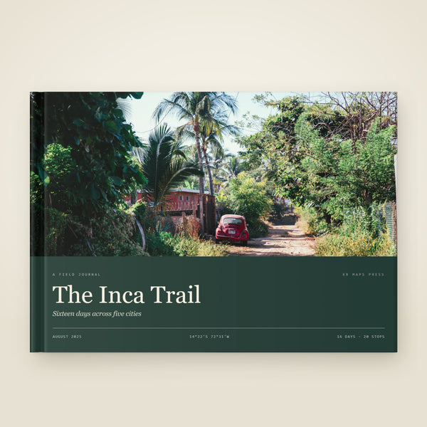 kr-paper:kr-maps-travel-book-hardcover:hero:3bea380d — A A4 landscape hardcover KR Maps Travel Book, closed on a table — a book of the Inca Trail, the title set over one of the trip's own photographs
