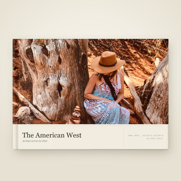kr-paper:kr-maps-travel-book-layflat:hero:43f07aa7 — A A4 landscape lay-flat KR Maps Travel Book, closed on a table — a book of a road trip across the American West, the title set over one of the trip's own photographs
