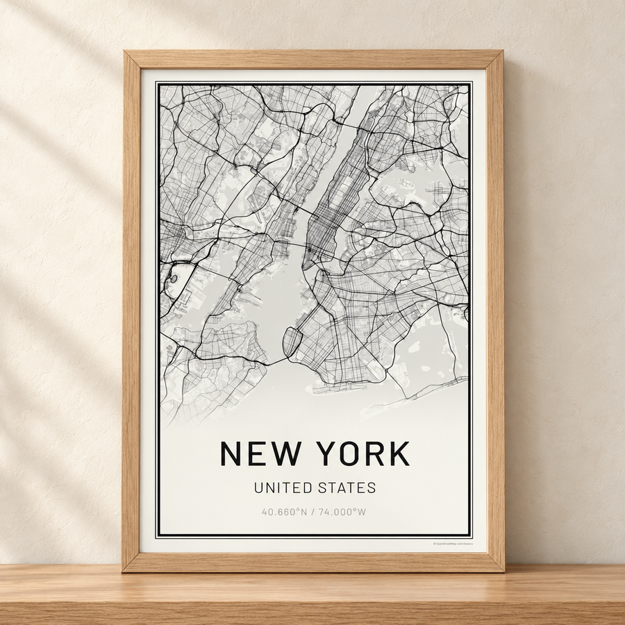 A New York City street map in an oak frame on a wooden shelf
