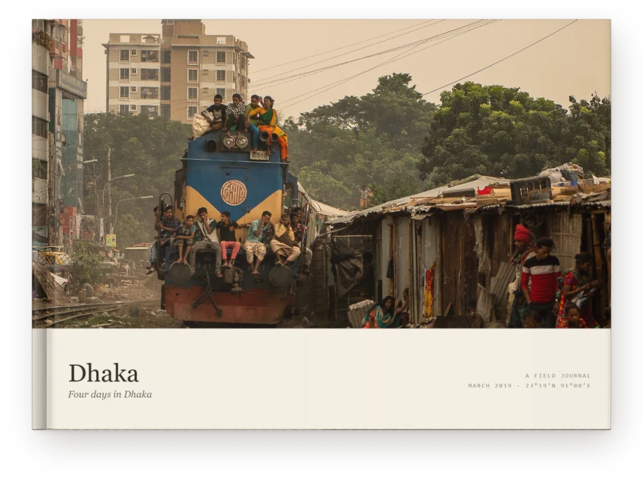 A Travel Book, closed on a table &mdash; a train south out of Dhaka