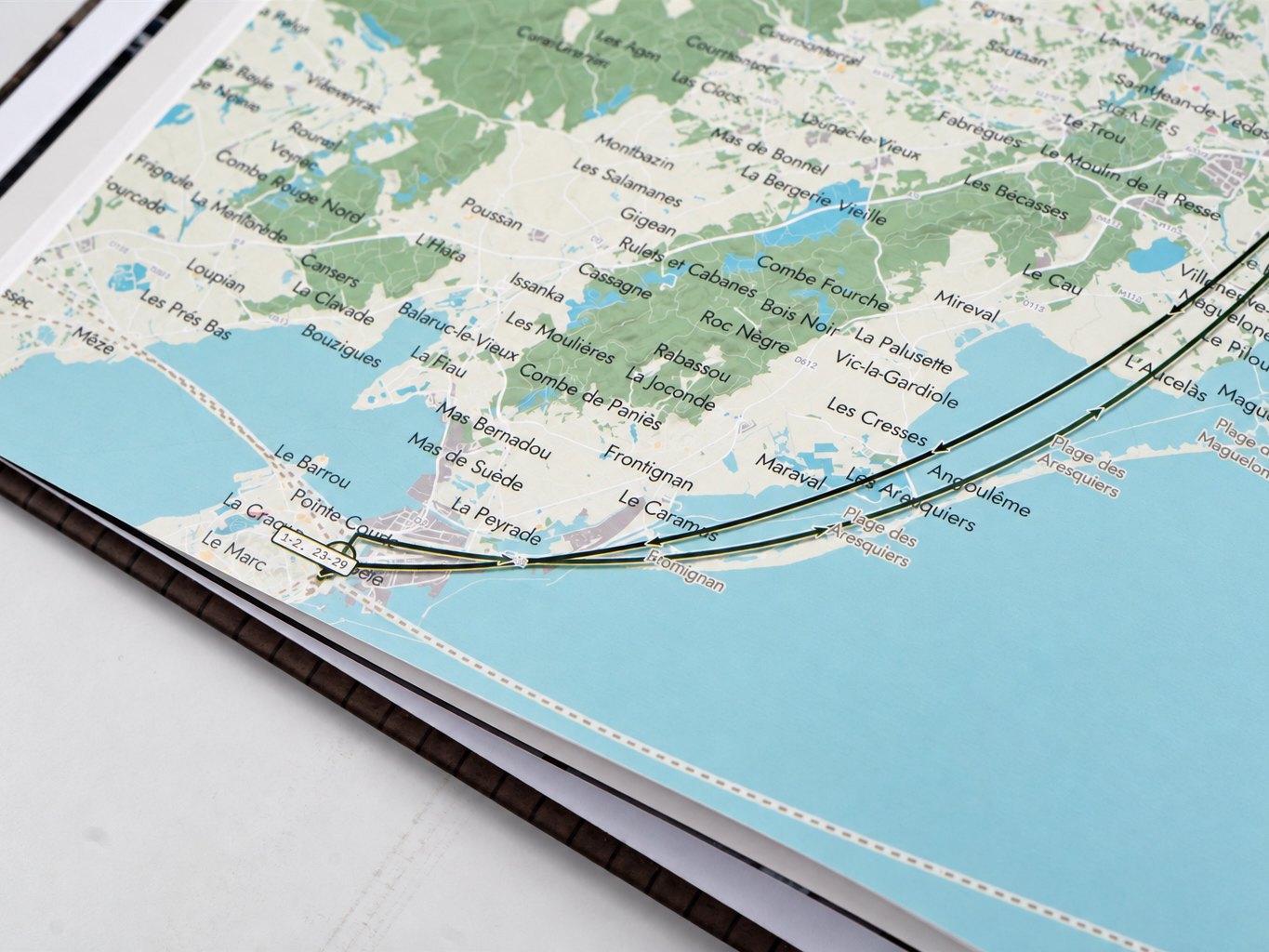 Close-up of a printed map page &mdash; town names and the route line along the coast at S&egrave;te